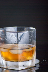 Whiskey Glass - Scotch Glass with ice cubes with background and shinny reflection on bottom