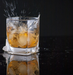 Whiskey Glass - Scotch Glass with ice cubes with background and shinny reflection on bottom