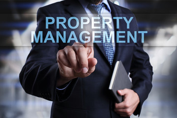 Businessman is pressing button on virtual screen and selecting Property Management.
