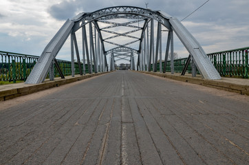 centennial metal bridge with wooden surface over Dzisna river
Dzisna, Belarus