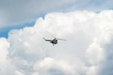 Green helicopter in the blue sky
