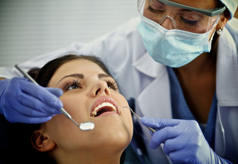 Woman dentist working at her patient  teeth