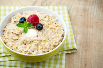Oatmeal porridge in bowl with berries raspberries and blackberri