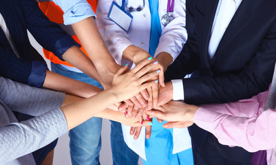 Portrait of people with various occupations putting their hands on top of each other