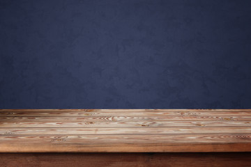 Empty wooden table against a blue wall.