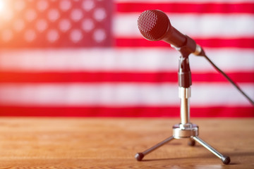 Microphone on US flag background. Table with microphone and banner. Radio show about to begin. Good...