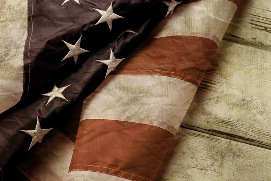 Old And Crumpled American Flag. Aged Flag On Wooden Background. We've Come A Long Way. Country With Strong Traditions.