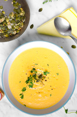 pumpkin soup in a bowl with spoon on a murble and .thyme