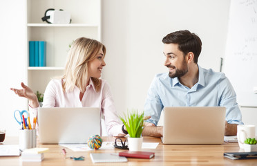 Skillful two workers are talking in office