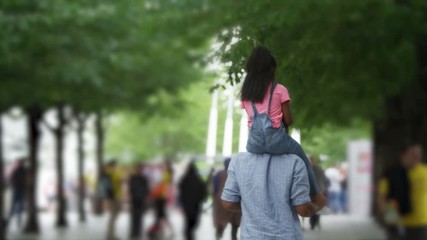African American father and daughter walking away from camera in urban park - Powered by Adobe