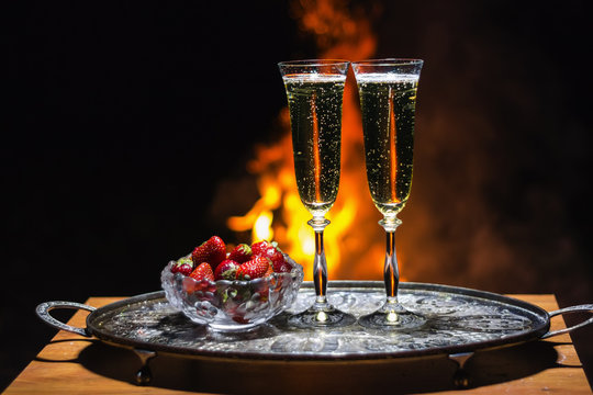 two glasses of champagne with flame on background