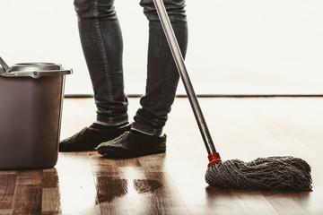 Closeup of human cleaning mopping floor.