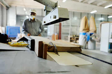 carpenter saws a board a circular saw