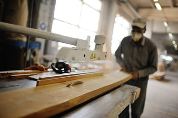 carpenter saws a board a circular saw