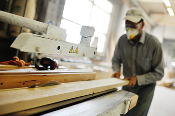 carpenter saws a board a circular saw