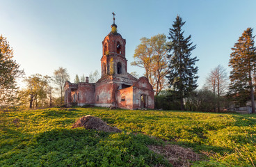 Fototapeta na wymiar Abandoned brick orthodox church at sunset