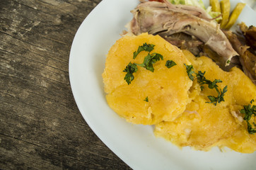 Traditional ecuadorian pork fritada typical serving, meat, potato tortillas on white plate