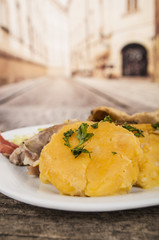 Traditional ecuadorian pork fritada typical serving, meat, potato tortillas on white plate