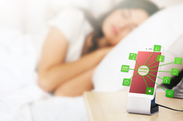 Smart home control concept. Smart phone near bed