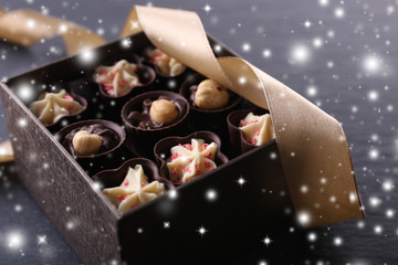 Chocolate sweets on wooden background with snow effect