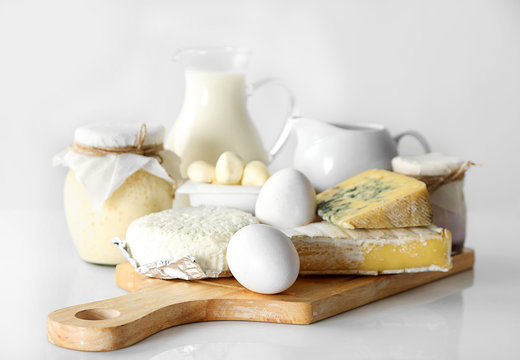 Set of fresh dairy products on wooden board, isolated  on white
