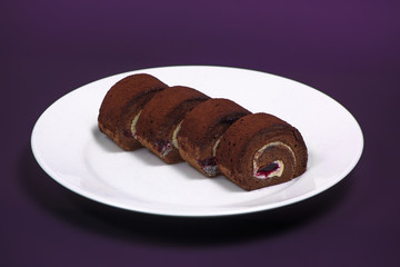 Delicious chocolate roll in plate on the background