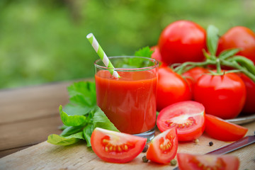 Fresh tomato juice on a wooden background
