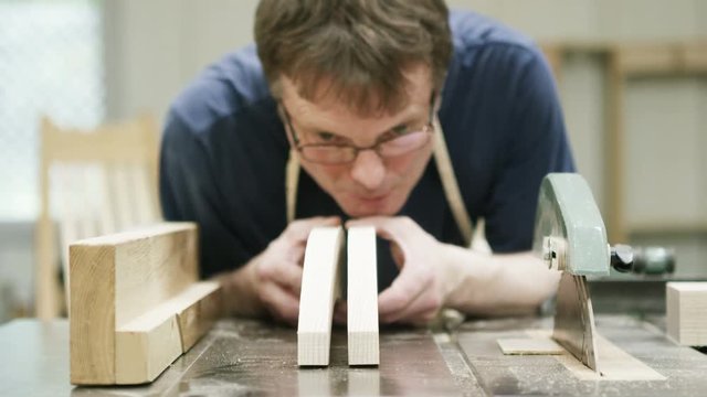  Furniture maker in his workshop, checking the quality of his work