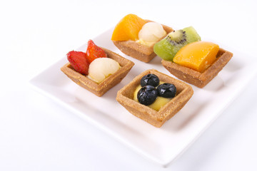 Assorted fruit tarts on square white plate