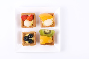 Assorted fruit tarts on square white plate