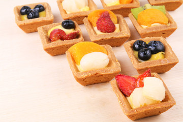 Assorted fruit tarts on wooden surface