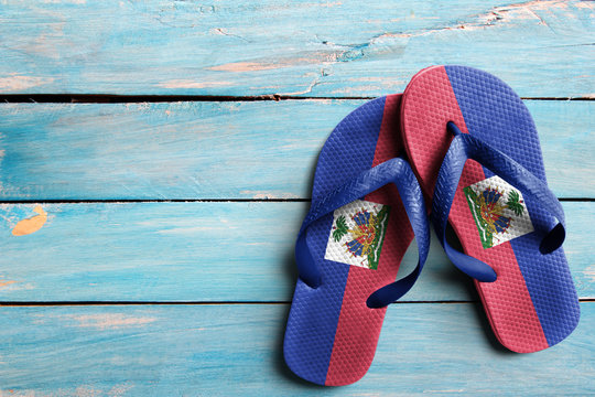 Thongs with flag of Haiti, on blue wooden boards