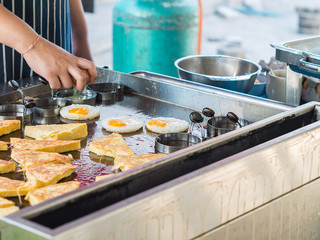 Chef cooking fried egg in shape form in hot pan