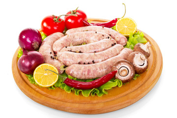 Uncooked sausages, vegetables and spices for grilling isolated on white.