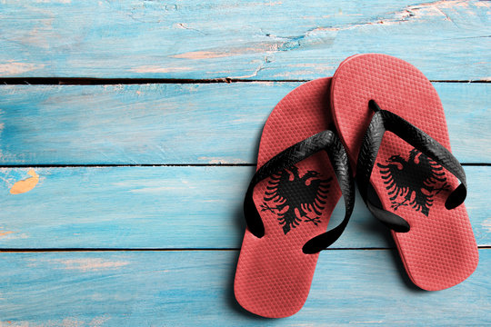 Thongs with flag of Albania, on blue wooden boards