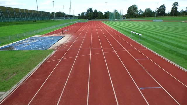  Drone footage of track athletes crossing finish line at running track