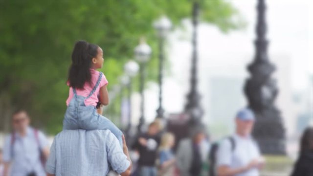  Happy father & daughter sightseeing in London, walking along path beside the river Thames. 