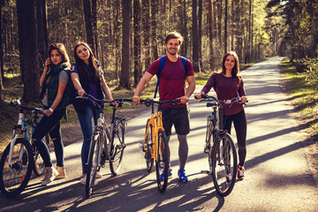 Four smiling adults with bicycles.