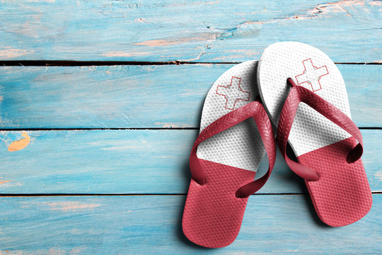 Thongs with flag of Malta, on blue wooden boards