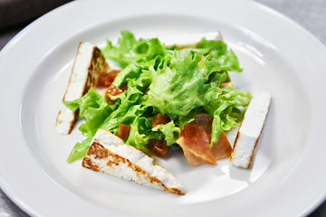 Dishes of fried cheese and green salad