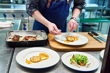 Cook are served at different dishes in restaurant