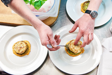 Cook are served dish with fish cutlet in restaurant