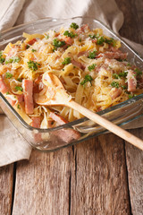 Austrian cuisine: noodles baked with ham and cheese close-up. vertical
