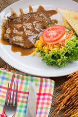 Beef steak with black pepper sauce , salad and French fries on s