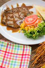 Beef steak with black pepper sauce , salad and French fries on s