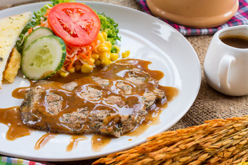 Beef steak with black pepper sauce , salad and French fries on s