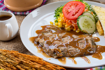 Beef steak with black pepper sauce , salad and French fries on s