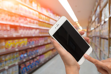 woman hold smart phone and burry supermarket background
