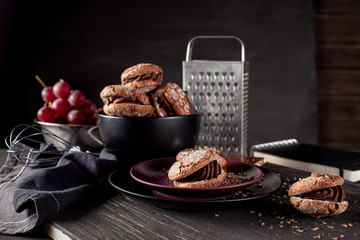 Chocolate cookies on dark wooden and blackboard background