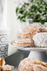 Biscuits on gray plate with cups of coffee with green and white